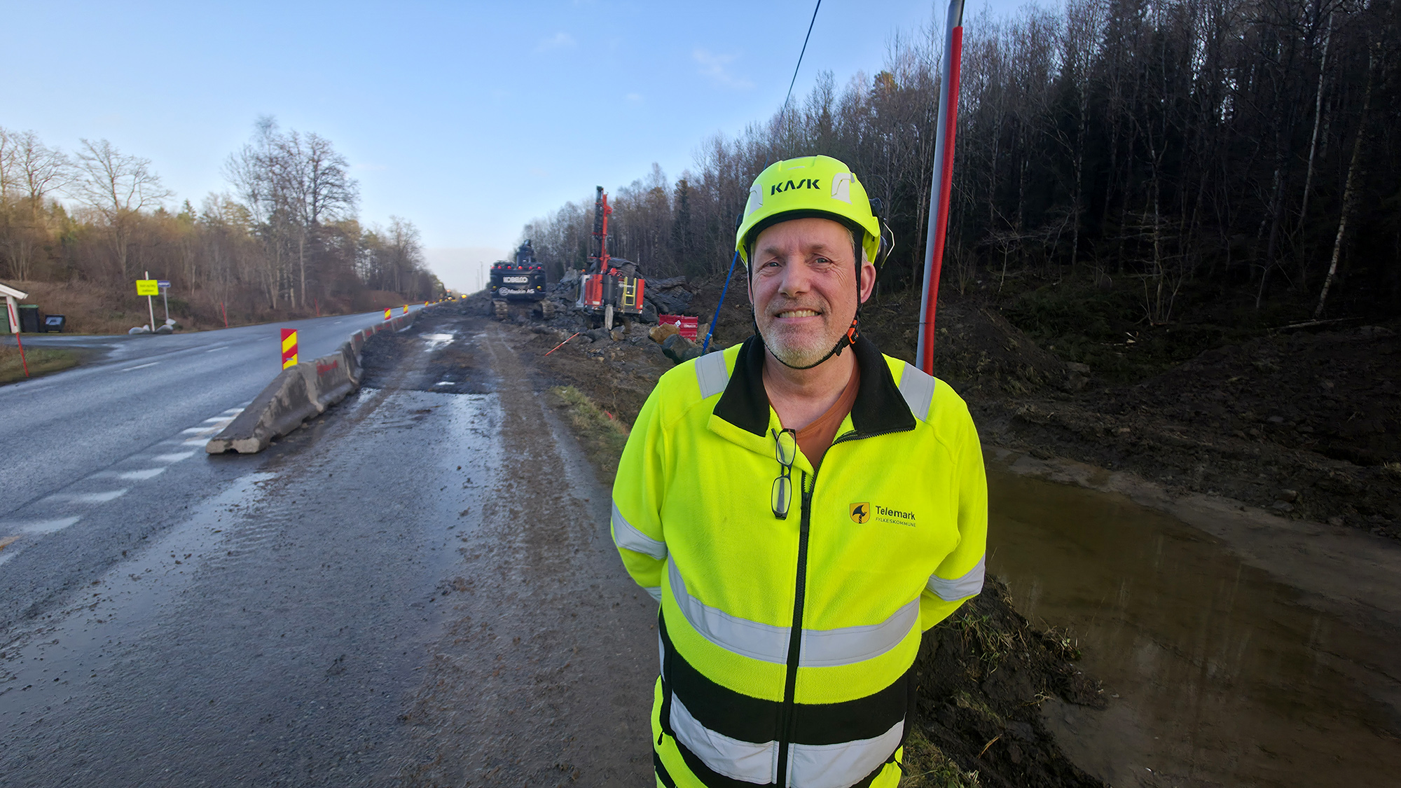 Bildet av byggeleder Øystein Jonhaugen foran arbeidsområdet hvor entreprenøren har begynt å skave vekk det øverste laget av området hvor gs-vegen blir bygget.