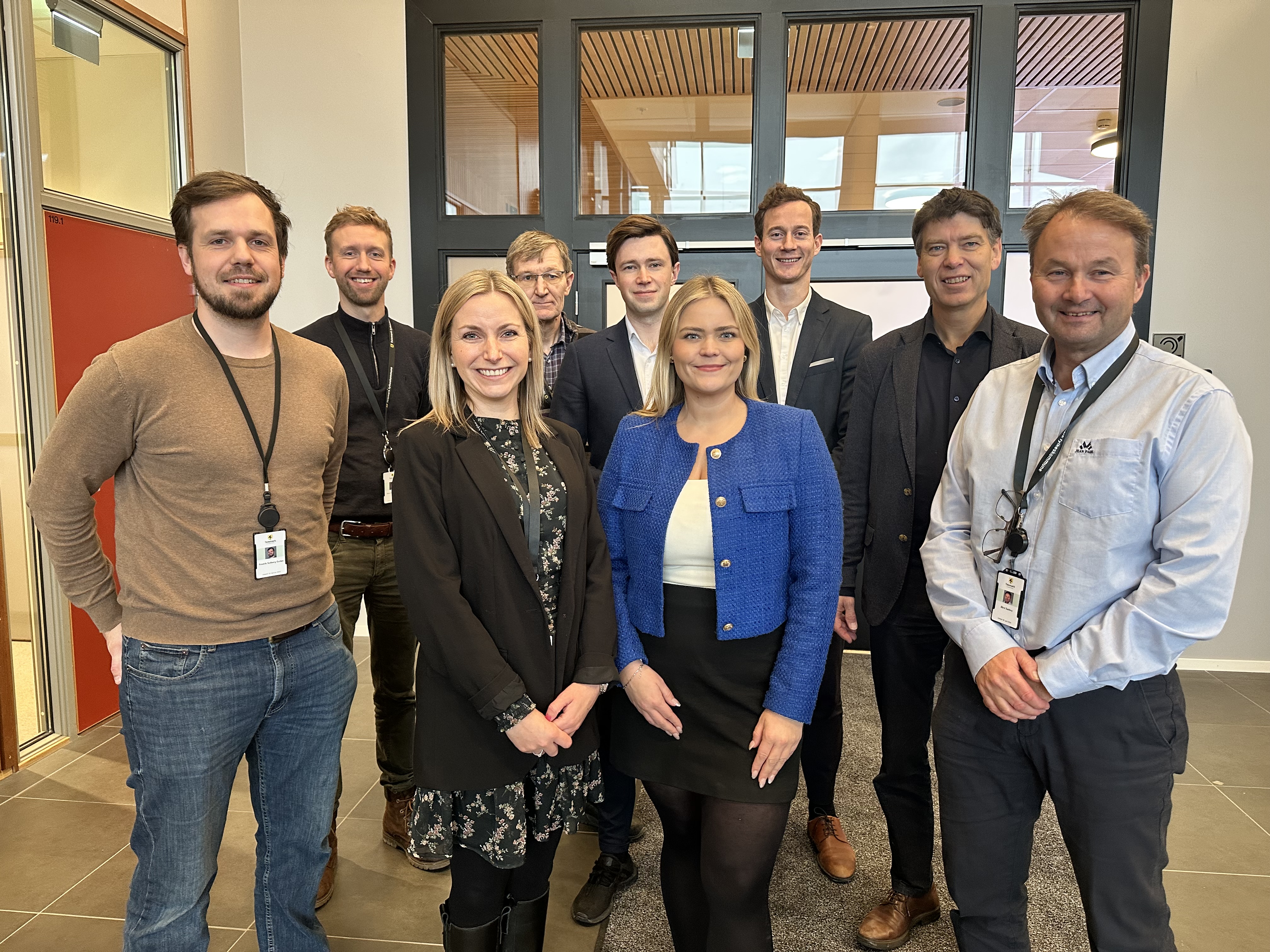 Bilde av en gruppe mennesker som står samlet foran en dør