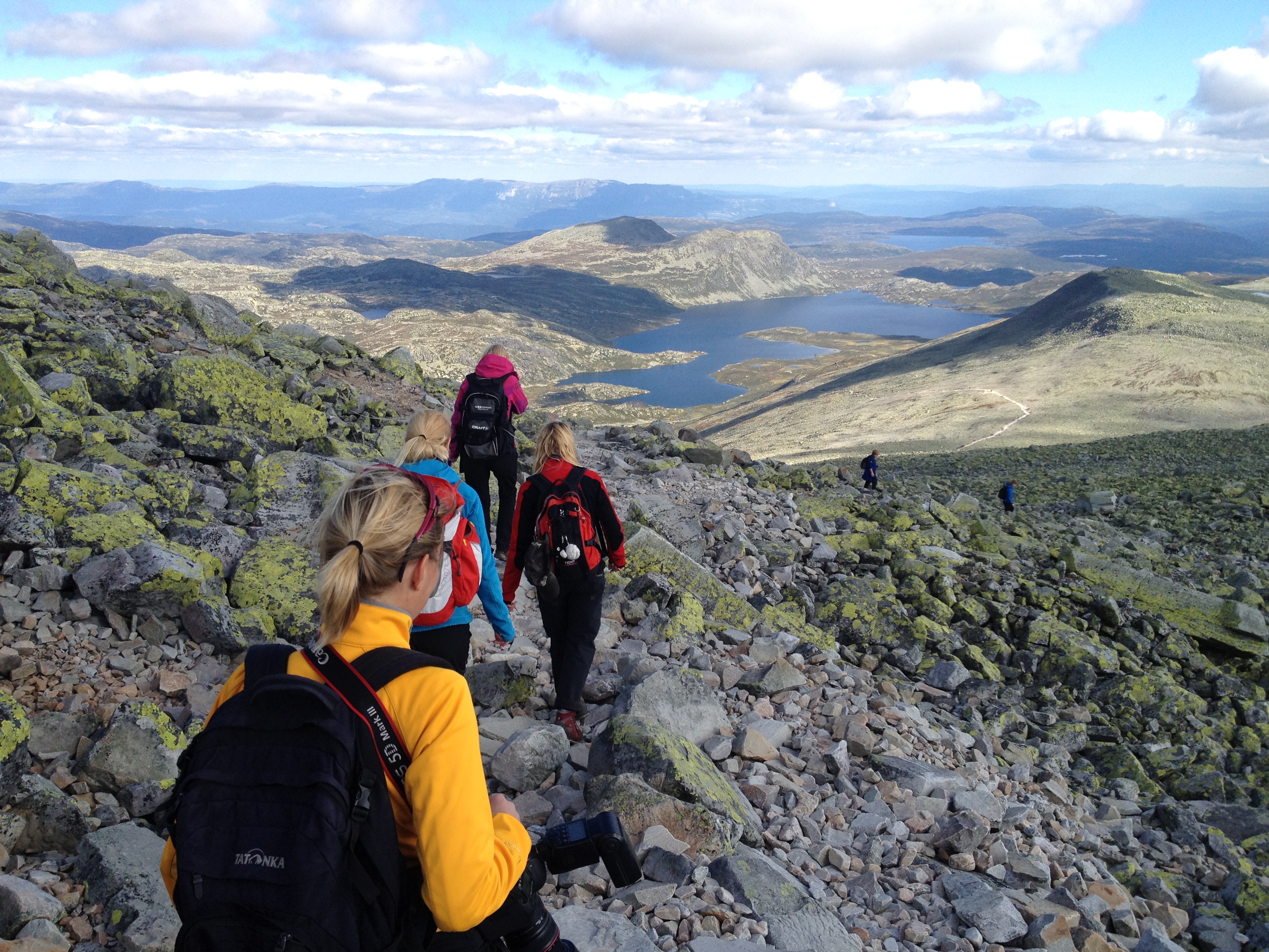 Turgåere med sekk på veg ned fra Gaustadtoppen