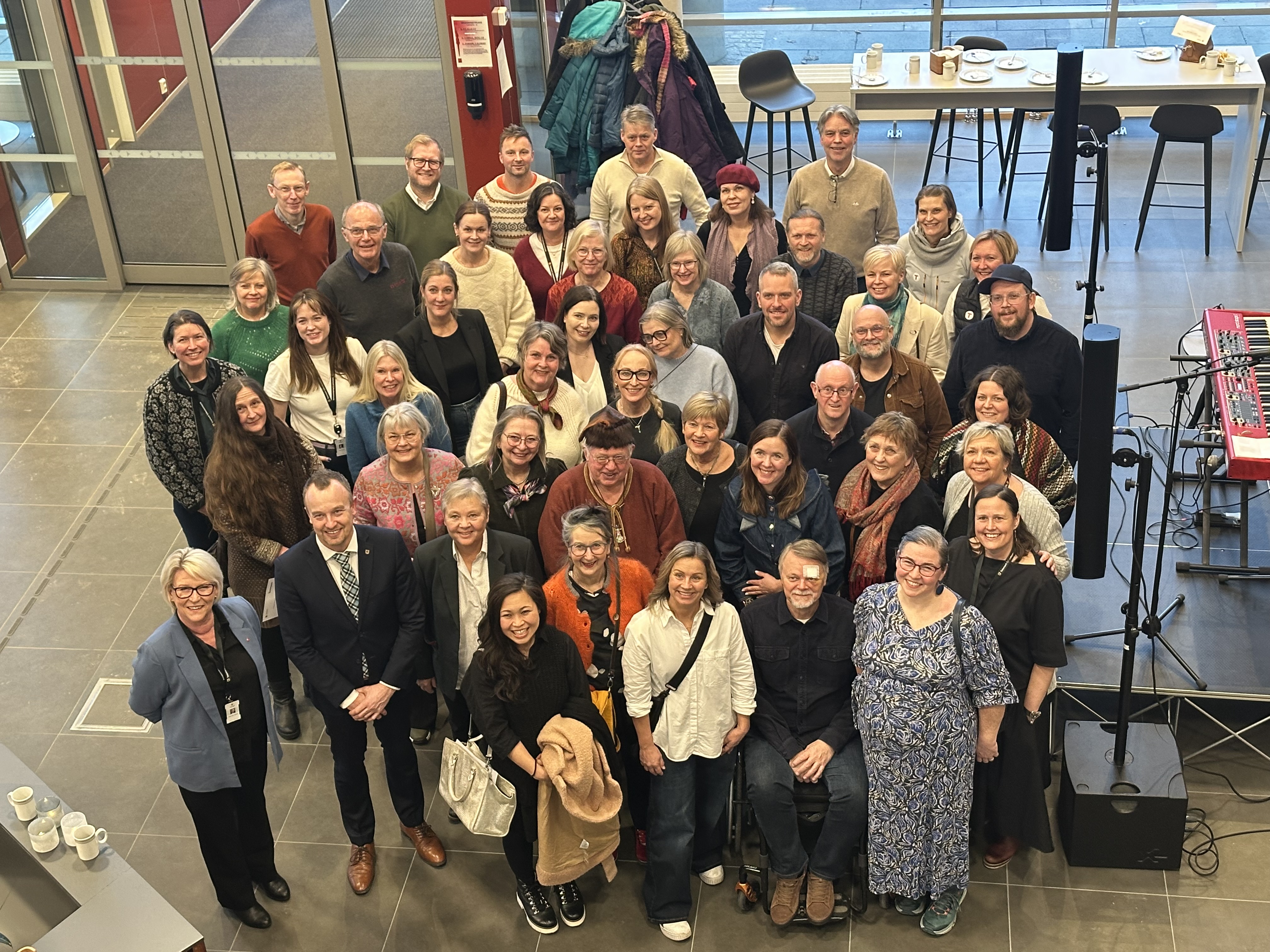 Mange mennesker ser opp mot fotografen, de har alle mottatt kulturpenger fra fylkeskommunen.