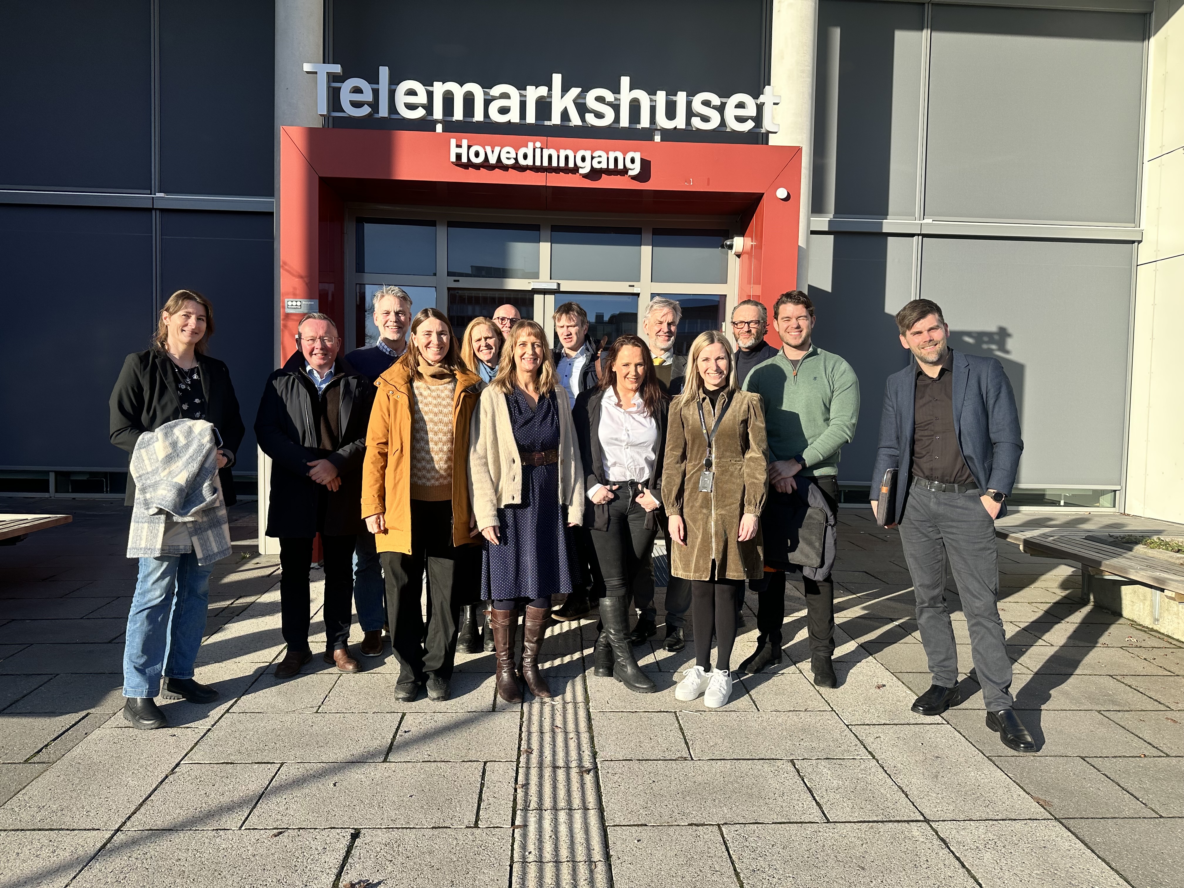 Gruppe med mennesker som står oppstilt foran Telemarkshuset i Skien
