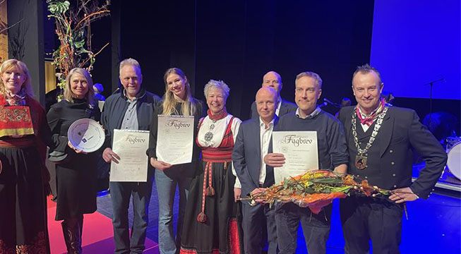 9 personer på en prisutdeling som smiler mot kamera