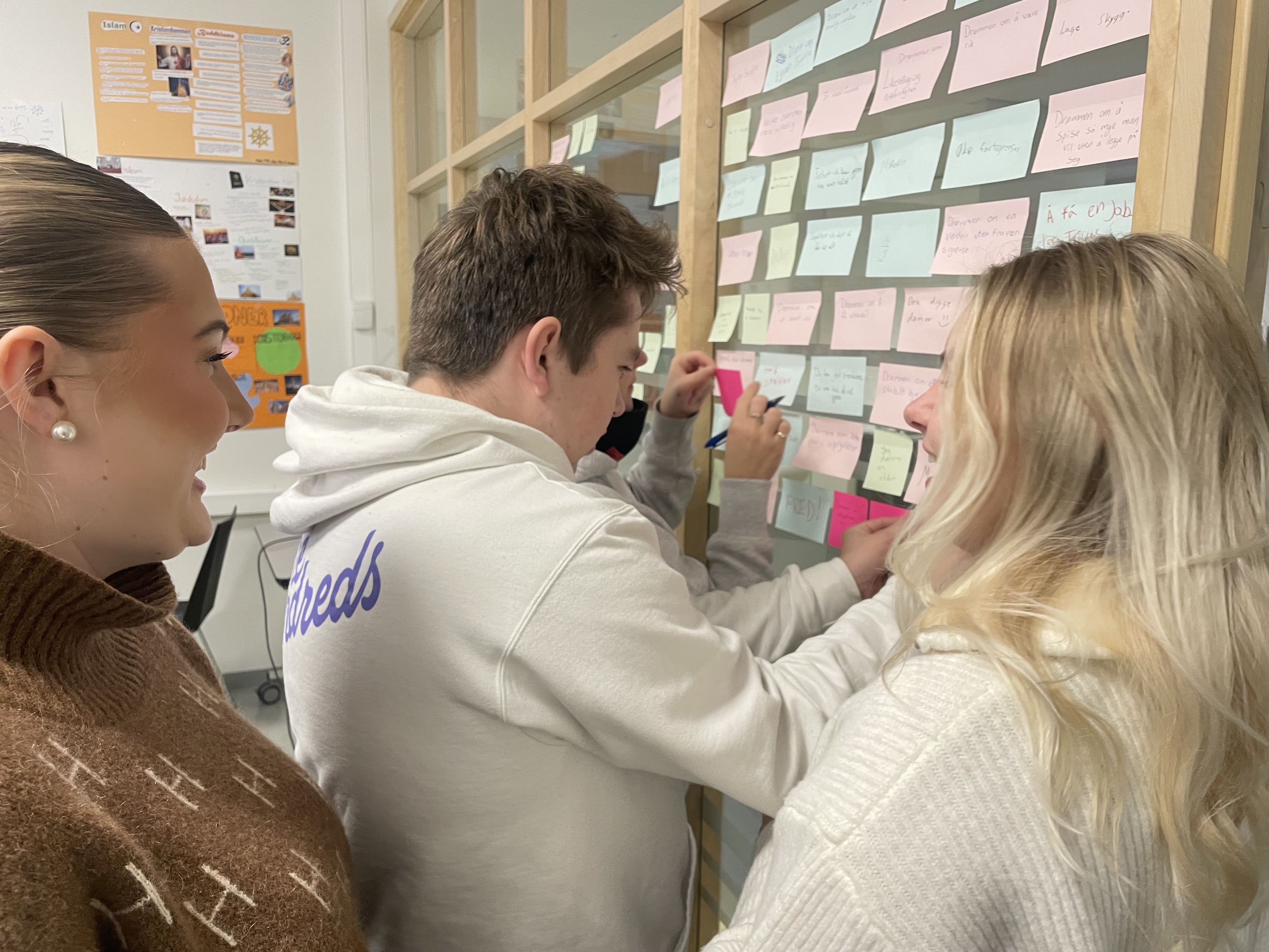 tre elever henger opp lapper