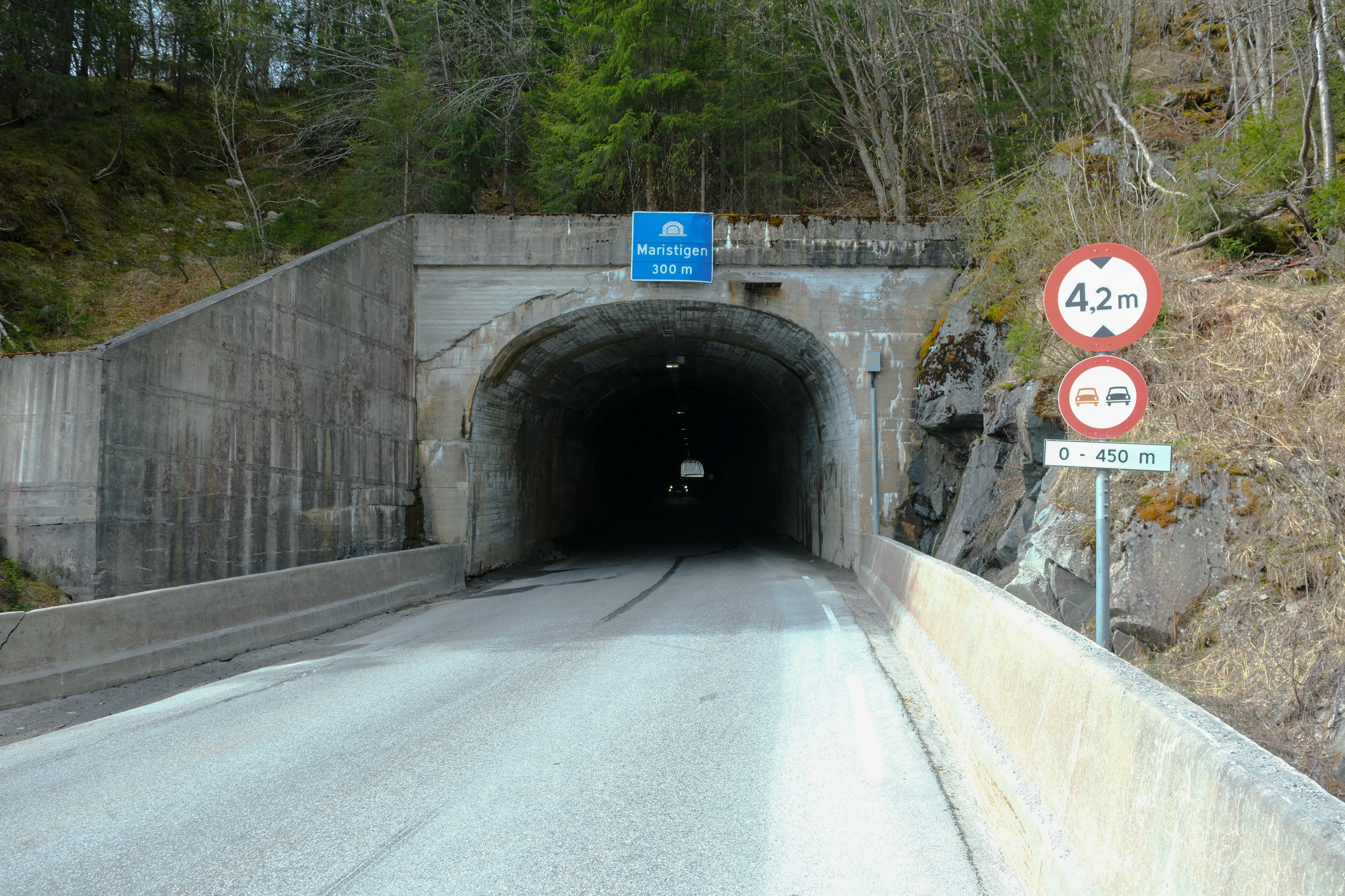 Tunnelåpningen på Maristigtunnelen midt i bilde, sideterreng rundt. Nordlig tunnelåpning kan skimtes gjennom tunnelen.