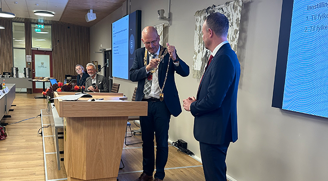 Mann med fylkesordførerkjedet til Telemark som skal overrekkes til en annen mann