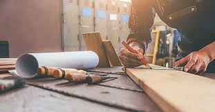 en tømrer tegner opp på en planke