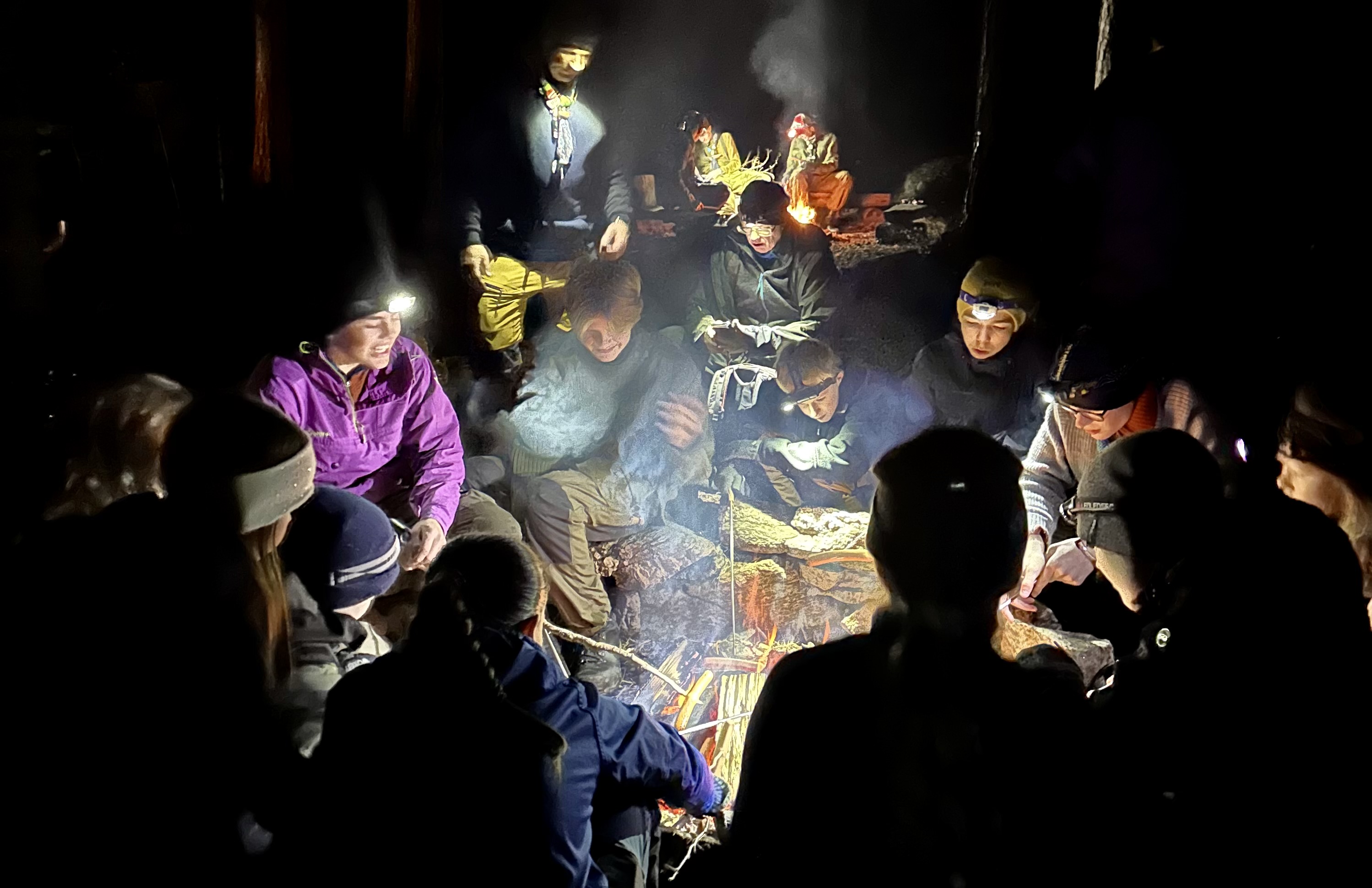 Barn sitter rundt et bål