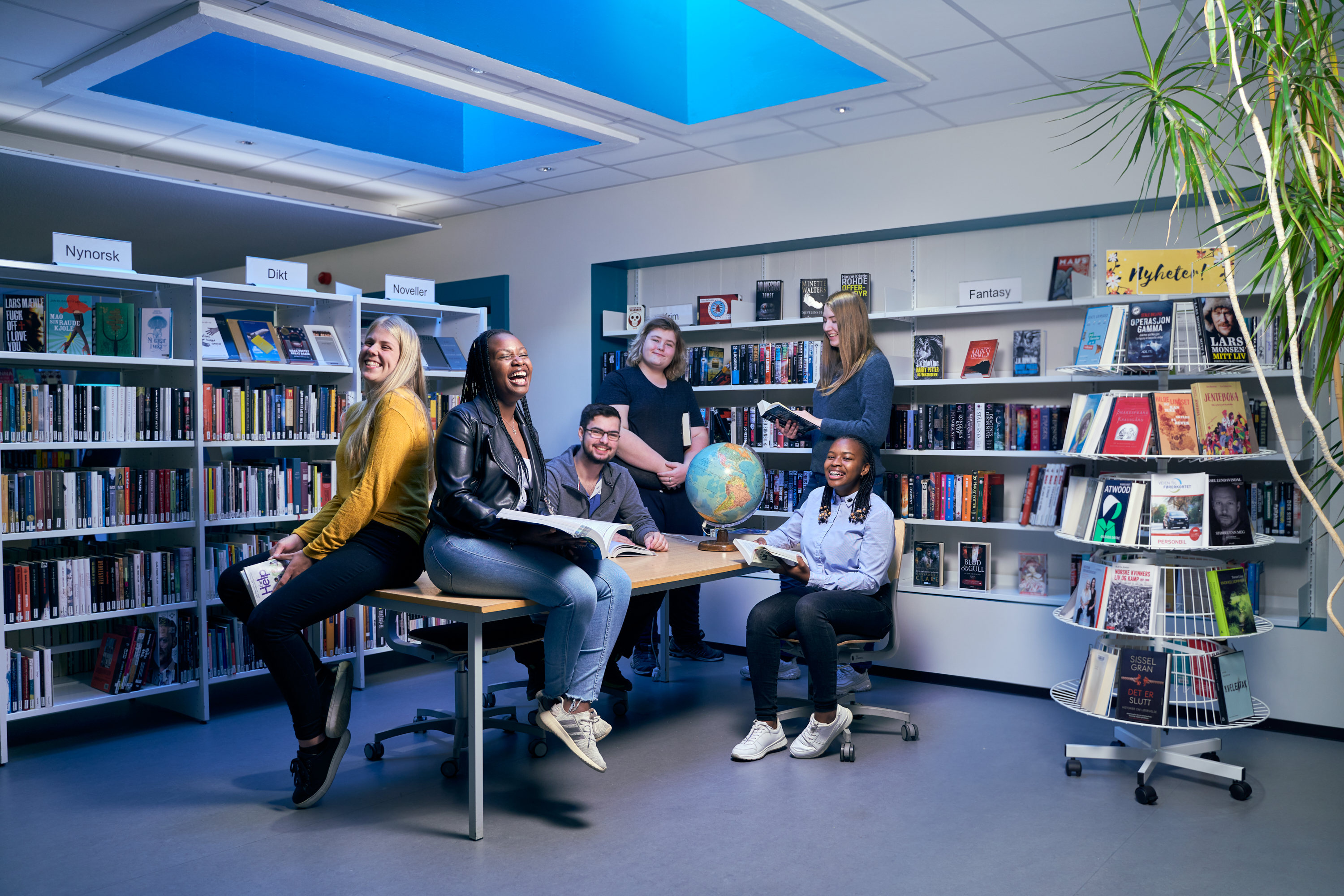 Elever på en skole sitter i en gruppe på et bibliotek