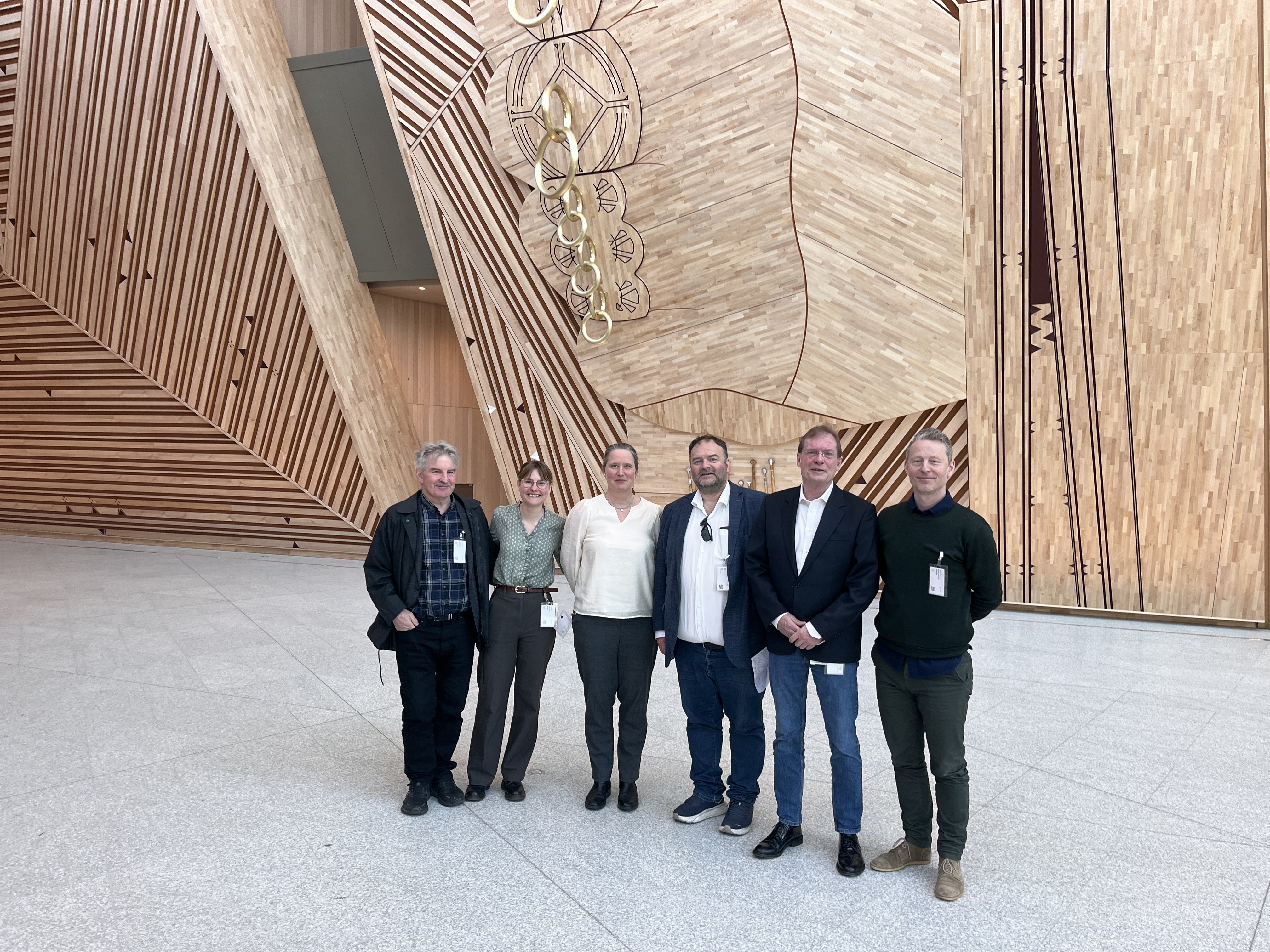 Mennesker som står foran kunst i tre.