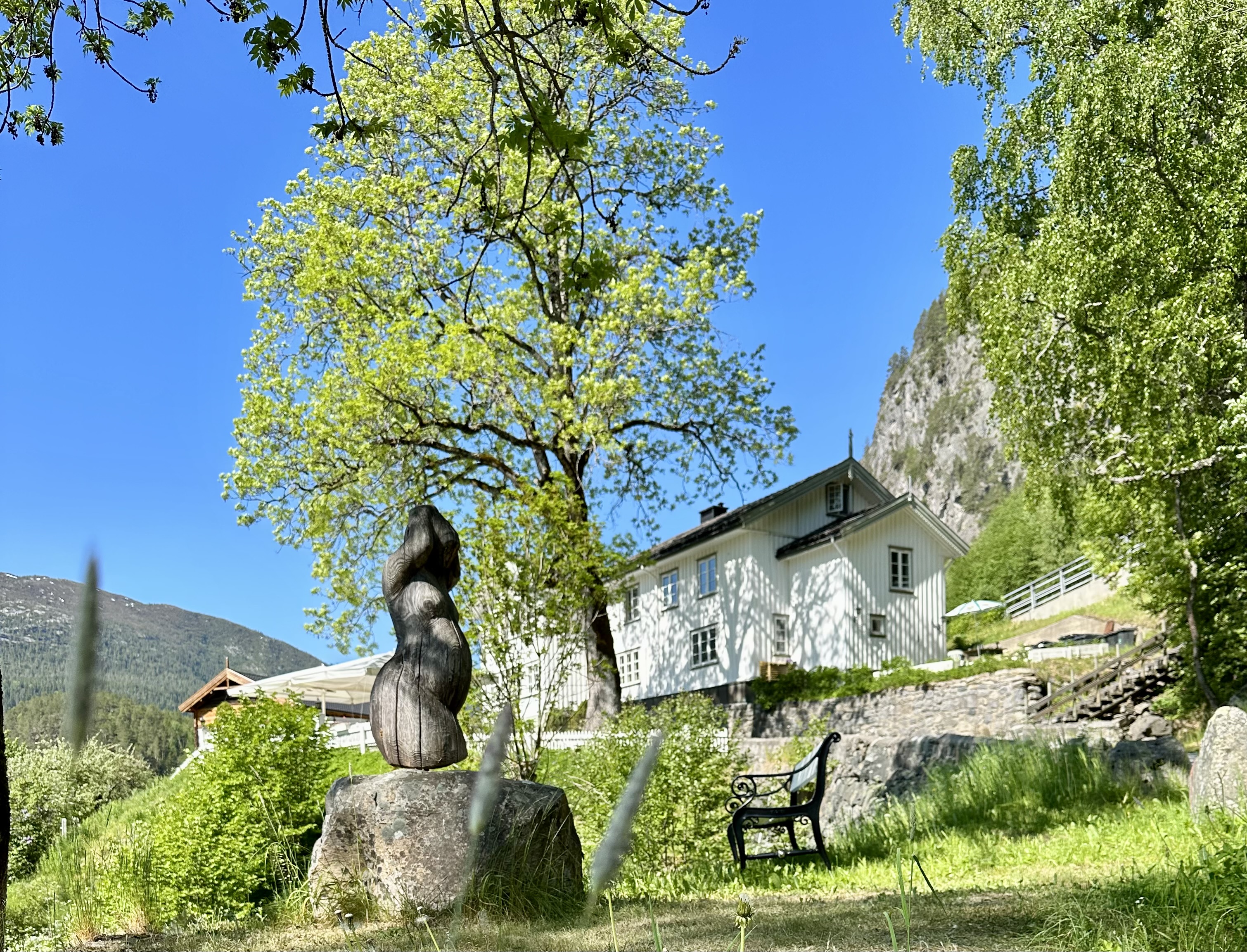 Eit kvitt hus med ein statue framom.